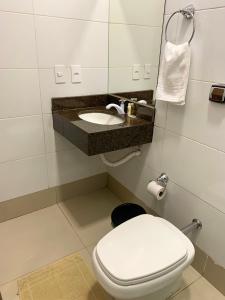 a bathroom with a toilet and a sink at Pousada Praeros in Rifaina +28 photos
