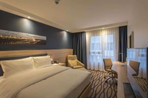 a hotel room with a bed and a desk at Hampton By Hilton Frankfurt Airport in Frankfurt/Main