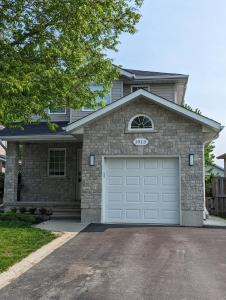 a house with a garage door in front of it at Adorable 4 bed,2 bath house in Kingston