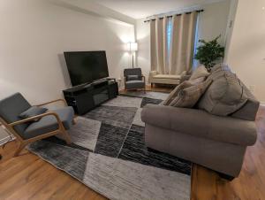 a living room with a couch and a flat screen tv at Adorable 4 bed,3 bath house in Kingston