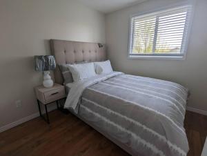 - une chambre avec un grand lit et une fenêtre dans l'établissement Adorable 4 bed,2 bath house, à Kingston