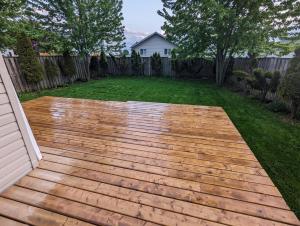 a backyard with a wooden deck in the yard at Adorable 4 bed,2 bath house in Kingston