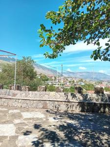 een stenen muur met een stad op de achtergrond bij Stone Pazar Guest House in Gjirokastër