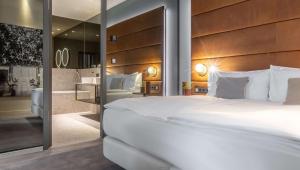 曼海姆Hilton Garden Inn Mannheim的卧室里有一张白色的大床和一面镜子