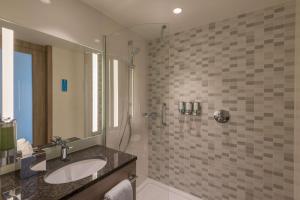 La salle de bains est pourvue d'un lavabo et d'une douche. dans l'établissement Hampton By Hilton Frankfurt City Centre East, à Francfort-sur-le-Main