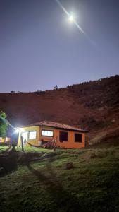 uma casa no meio de um campo à noite em Casa Cambuí Hospedagem Rural em Rio Prêto
