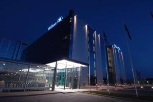 a building with a sign on the side of it at night at Hilton Helsinki Airport in Vantaa