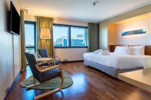 a hotel room with a bed and a desk and a chair at Hilton Helsinki Airport in Vantaa