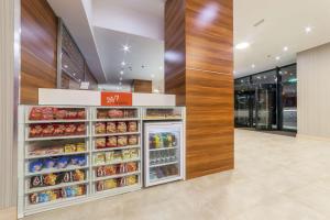 a grocery store aisle with an open refrigerator at Hampton By Hilton Iasi in Iaşi