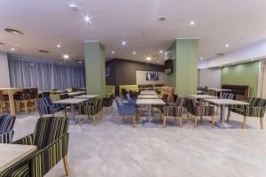 een restaurant met tafels en stoelen in een kamer bij Hampton By Hilton Iasi in Iaşi