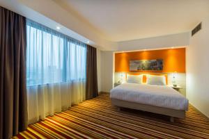 - une chambre avec un lit et une grande fenêtre dans l'établissement Hampton By Hilton Iasi, à Iaşi