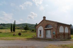 a small brick building in the middle of a field at Opera d'Oro in Piegaro