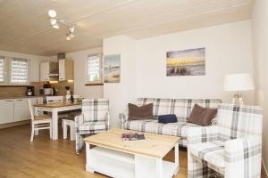 a living room with a couch and a table at modernes Ferienhaus mit eigener Terrasse und kleinem Garten - Ferienhaus Liva in Dranske