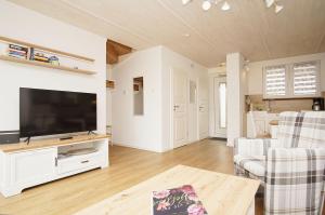 a living room with a large flat screen tv at modernes Ferienhaus mit eigener Terrasse und kleinem Garten - Ferienhaus Liva in Dranske