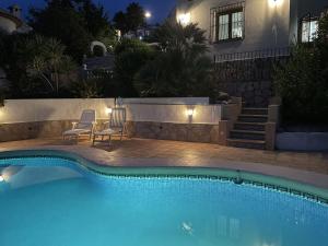 uma piscina em frente a uma casa à noite em Belvilla by OYO Antonio Grande 9 pax em Benichembla