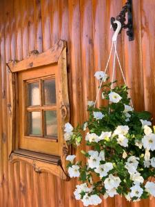 un espejo y flores en una pared con una ventana en Ivona - Kuća za odmor Perušić - Stara Lika, en Perušić