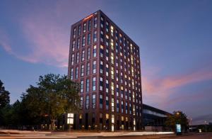 a tall brown building with lights on at Hampton By Hilton Kiel in Kiel