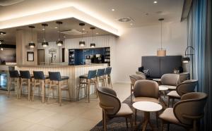 a bar in a restaurant with chairs and a counter at Hampton By Hilton Kiel in Kiel