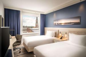 um quarto de hotel com duas camas e uma janela em Hampton By Hilton Kiel em Kiel
