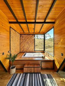 - une salle de bains avec baignoire dans une chambre dotée de murs en bois dans l'établissement Cabanas River House Urubici - Chalé River House e Chalé Bela Vista, à Urubici