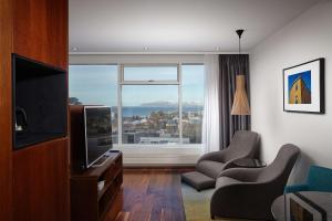a living room with a television and a large window at Hilton Reykjavik Nordica in Reykjavík