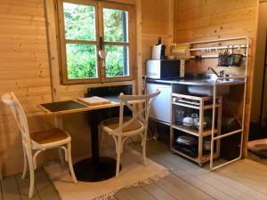 - une cuisine avec une table et des chaises dans la chambre dans l'établissement Tiny House Close to Brussels South Charleroi Airport, à Courcelles