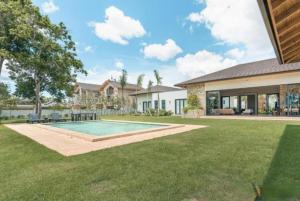een achtertuin met een zwembad en een huis bij Sunny Vacation Villa No 73 in San Rafael del Yuma