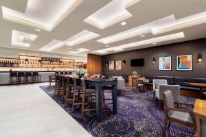 um restaurante com mesas e cadeiras e um bar em DoubleTree by Hilton Krakow Hotel & Convention Center em Cracóvia