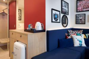 Hampton By Hilton Kaiserslautern في كايزرسلاوترن: غرفة معيشة مع أريكة زرقاء وطاولة