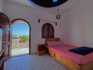a bedroom with a bed and a large window at Nook seaview in Dahab