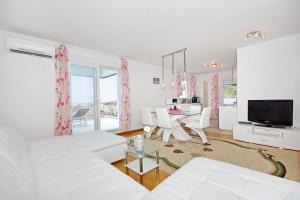 a white living room with a white couch and a table at Tatiana Penthouse in Podstrana
