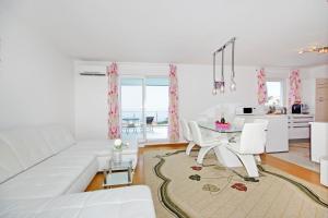 a white living room with a white couch and a table at Tatiana Penthouse in Podstrana