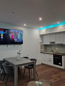 a kitchen with a table and a tv on the wall at Villa Pearl Adriatic Coast 4 in Golem +32 photos