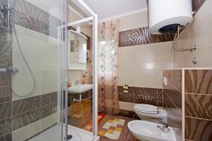 a bathroom with a toilet and a sink and a shower at Tatiana Penthouse in Podstrana +11 photos