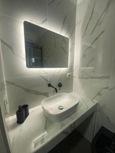 Baño blanco con lavabo y espejo en Rossella Silver House, en Minturno