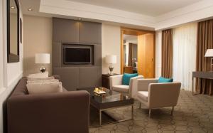 a living room with a couch and chairs and a television at DoubleTree by Hilton Kazan City Center in Kazan