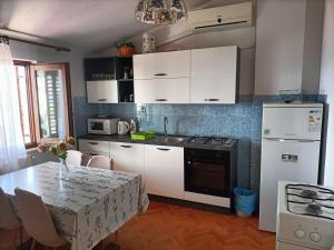 a kitchen with white appliances and a table with chairs at Apartment Zdenka 1 in Trogir