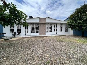 a white house with black shuttered windows on it at Home Acacias in Acacías