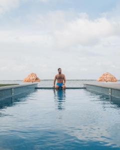 サン・ペドロにあるPlaya De Sala Boutique Hotelの海に座る男