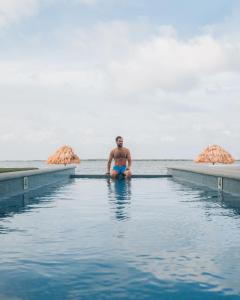 a man sitting in the water in the ocean at Playa De Sala Boutique Hotel, Adults Only in San Pedro