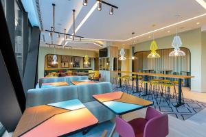 a lobby with tables and chairs and a restaurant at Hampton By Hilton Alcobendas Madrid in Alcobendas