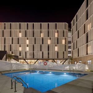 uma piscina em frente a um edifício à noite em Hampton By Hilton Alcobendas Madrid em Alcobendas