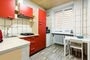 eine Küche mit roten Schränken und einem Waschbecken in der Unterkunft Juozapaviciaus apartment in Kaunas