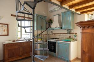 une cuisine avec des armoires bleues et un escalier en colimaçon dans l'établissement Opera d'Oro, à Piegaro
