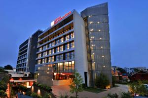 un gran edificio con luces en el lateral en Hilton Garden Inn Milan North, en Milán