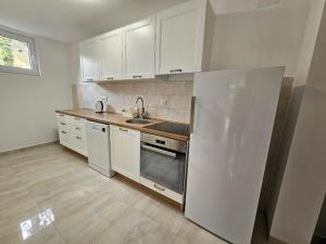 una cucina con mobili bianchi, un lavello e un frigorifero di Guesthouse Silva a Vinci