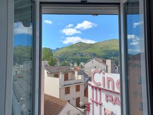 une fenêtre avec vue sur la ville et les montagnes dans l'établissement Le Peyragudes - Rue de la Grotte - 36m, à Lourdes