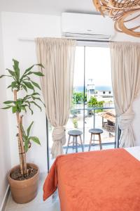 a bedroom with a bed and a large window at Apartamento Terracota Recreio - 2 quartos com vista para o mar in Rio de Janeiro