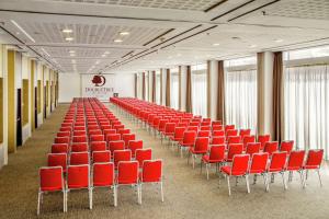 - une rangée de chaises rouges dans une grande pièce dans l'établissement DoubleTree By Hilton Milan, à Milan