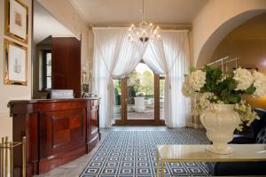 una sala de estar con un jarrón de flores sobre una mesa en Grand Hotel Villa Torretta, Curio Collection by Hilton, en Sesto San Giovanni